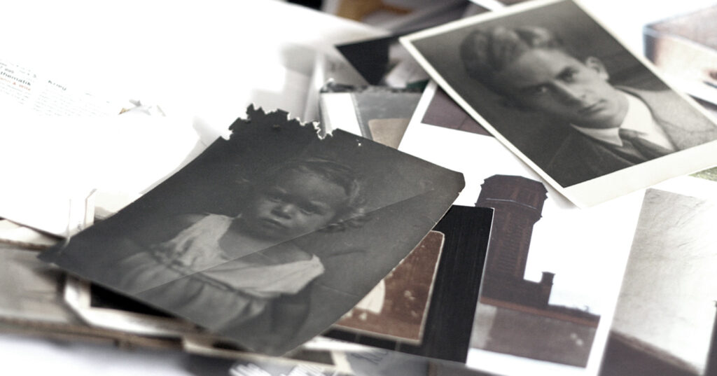 Fotos und Dokumente liegen durcheinander auf einem Tisch, darunter ein Foto von meinem Vater als Kleinkind, ein Foto von Theo Hespers aus den 20ern, Fotos der Gedenkstätte Plötzensee und Briefe.