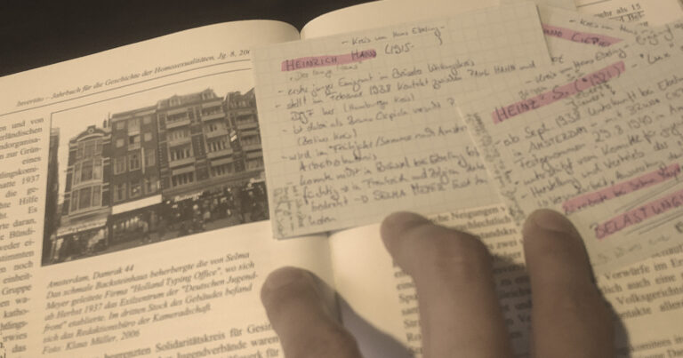 In der Invertito ist ein Foto vom Gebäude, in dem das Holland Typing Office von Selma Meyer war. Auf dem Buch liegen Karteikarten mit den Namen zweier geflüchteter Junger Männer aus Deutschland.